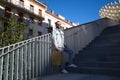 Handsome young man with beard comes down stairs with shopping bag in hand. Man is dressed casually and in modern clothes. Shopping