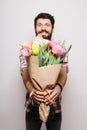 Handsome young man with beard pointed on camera nice bouquet of flowers Royalty Free Stock Photo