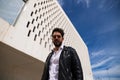 Handsome young man with beard, sculpted body, walking through the park before arriving at the building where he works as office Royalty Free Stock Photo