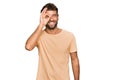 Handsome young man with beard wearing casual tshirt doing ok gesture with hand smiling, eye looking through fingers with happy Royalty Free Stock Photo