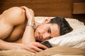 Handsome young man in bed typing on cell phone Royalty Free Stock Photo