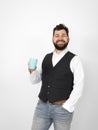 Handsome, young man with black beard posing with turquoise coffee cup or tea cup in front of white background