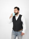 Handsome, young man with black beard posing with turquoise coffee cup or tea cup in front of white background