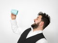 Handsome, young man with black beard posing with turquoise coffee cup or tea cup in front of white background