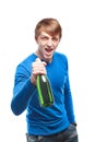 Handsome young man in a blue sweater with a bottle of champagne Royalty Free Stock Photo