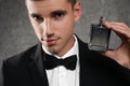 Handsome young man with bottle of  on grey stone Royalty Free Stock Photo