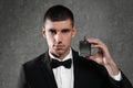 Handsome young man with bottle of perfume on grey background Royalty Free Stock Photo