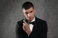 Handsome young man with bottle of perfume on stone background Royalty Free Stock Photo