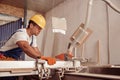 Serious male worker using woodworking equipment in workshop Royalty Free Stock Photo