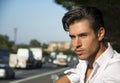 Handsome young man and busy road with traffic