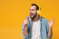 Handsome young man in casual blue shirt posing isolated on yellow orange background studio portrait. People lifestyle Royalty Free Stock Photo