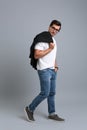 Handsome young man in casual clothes with jacket and glasses on grey background Royalty Free Stock Photo
