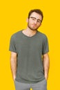 Handsome young man in casual wear and eye glasses posing on yellow background. Stylish bearded smart casual look hipster Royalty Free Stock Photo