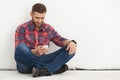 Handsome young man in casual wear typing text message. Royalty Free Stock Photo