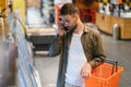 Handsome young man check the fridges for frozen food in the supermarket. Royalty Free Stock Photo