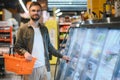 Handsome young man check the fridges for frozen food in the supermarket. Royalty Free Stock Photo