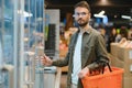 Handsome young man check the fridges for frozen food in the supermarket. Royalty Free Stock Photo