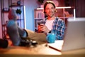 Handsome young man in checkered shirt put his feet on table with modern smartphone in hands. Royalty Free Stock Photo