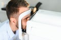 Handsome young man is checking the eye vision in modern ophthalmology clinic. Patient in ophthalmology clinic