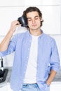 Handsome young man with coffee cup near head, suffer from pain, in the morning at kitchen Royalty Free Stock Photo