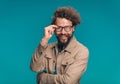 Handsome young man crossing arms and adjusting eyeglasses Royalty Free Stock Photo