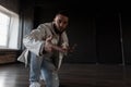 Handsome young man dancer in fashionable jacket and ripped jeans