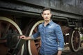 Handsome young man in denim shirt in front of old train Royalty Free Stock Photo