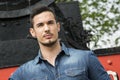 Handsome young man in denim shirt in front of old train Royalty Free Stock Photo