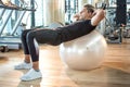 Handsome young man doing abs exercise on fitness ball at gym Royalty Free Stock Photo
