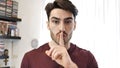 Handsome young man doing Hush sign with finger on lips Royalty Free Stock Photo