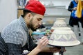 Young man drawing pottery clay pots in Fez.Morocco