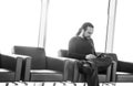 Handsome young man with dreadlocks using his digital tablet pc at an airport lounge, modern waiting room, with backlight Royalty Free Stock Photo