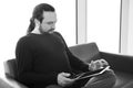 Handsome young man with dreadlocks using his digital tablet pc at an airport lounge, modern waiting room, with backlight Royalty Free Stock Photo