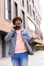 Handsome young man dressed casually spending time outdoors at the city, using mobile phone while walking down stairs Royalty Free Stock Photo