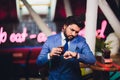 Handsome young man drinking cocktail at bar counter, wearing business suit. Royalty Free Stock Photo