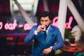 Handsome young man drinking cocktail at bar counter, wearing business suit. Royalty Free Stock Photo