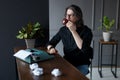 Young man in black shirt and eye glasses, drink coffee on working desk for work idea, over gray interiors. Royalty Free Stock Photo