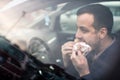 Handsome young man eating a hurried lunch in his car Royalty Free Stock Photo