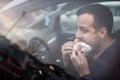 Handsome young man eating a hurried lunch in his car Royalty Free Stock Photo