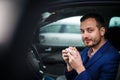 Handsome young man eating a hurried lunch in his car Royalty Free Stock Photo