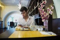 Handsome young man in elegant restaurant using cell phone