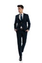 handsome young man in elegant suit holding hands in pockets Royalty Free Stock Photo