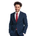 Handsome young man in elegant suit smiling and posing with hands in pockets Royalty Free Stock Photo