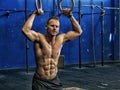 Handsome young man exercising with rings