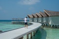 Handsome young man in fashionable white t-shirt and black shorts at over water villas at tropical island luxury resort Royalty Free Stock Photo