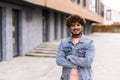 Handsome young man with folded arms. Beautiful portrait of laughing joyful cheerful men with crossed hands in a city Royalty Free Stock Photo