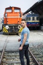 Handsome young man in front of old train, looking away Royalty Free Stock Photo