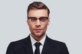 Successful professional. Handsome young man in full suit looking at camera while standing against grey background Royalty Free Stock Photo