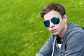 Handsome young man with glasses sitting on the grass Royalty Free Stock Photo
