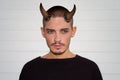 Handsome young man with halloween horns and blue eyes Royalty Free Stock Photo